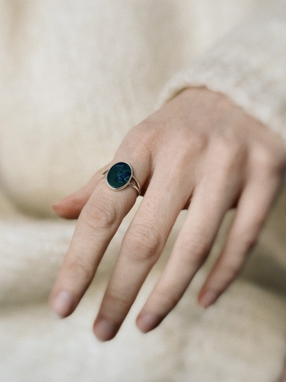Oval nephrite from Lower Silesia set in a sterling silver ring worn on the hand in a winter-inspired scene.