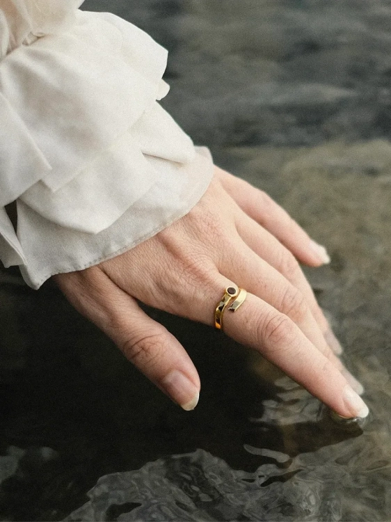 Gold-plated amber ring worn on the hand, inspired by sea waves