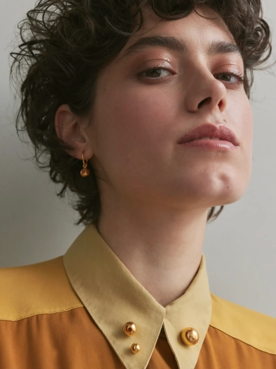 Modern gold-plated sphere brooches styled on clothing