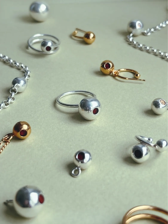 Handcrafted silver ring featuring a sculptural ball with amber detail