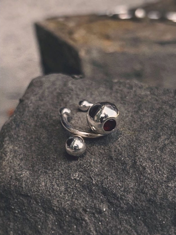 Detail of sterling silver ear cuff with polished spheres and amber accent