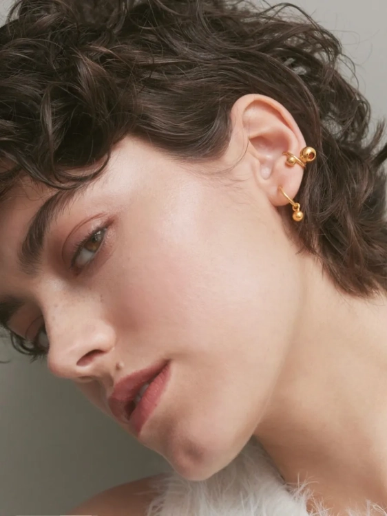 Gold-plated ear cuff with spherical design worn on the ear