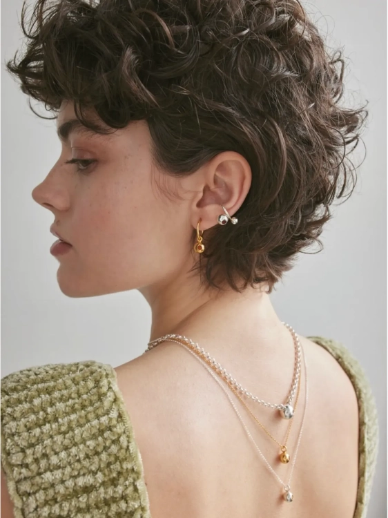 Gold-plated hoop earrings with spherical design worn by model