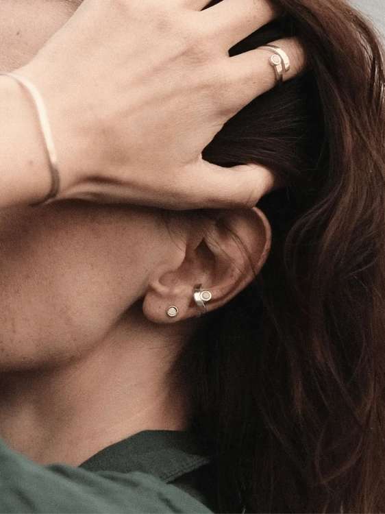 Silver ear cuff with amber worn on the ear as a modern accent