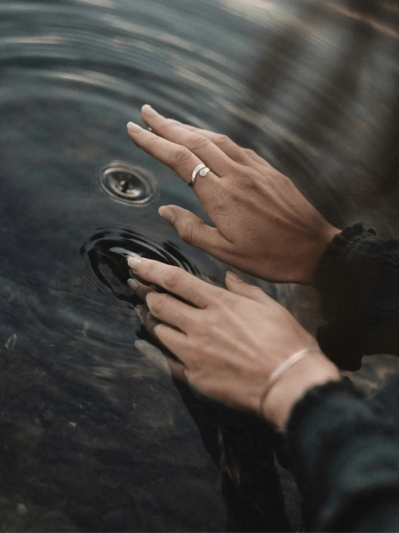 Silver amber ring worn on the hand, inspired by sea waves