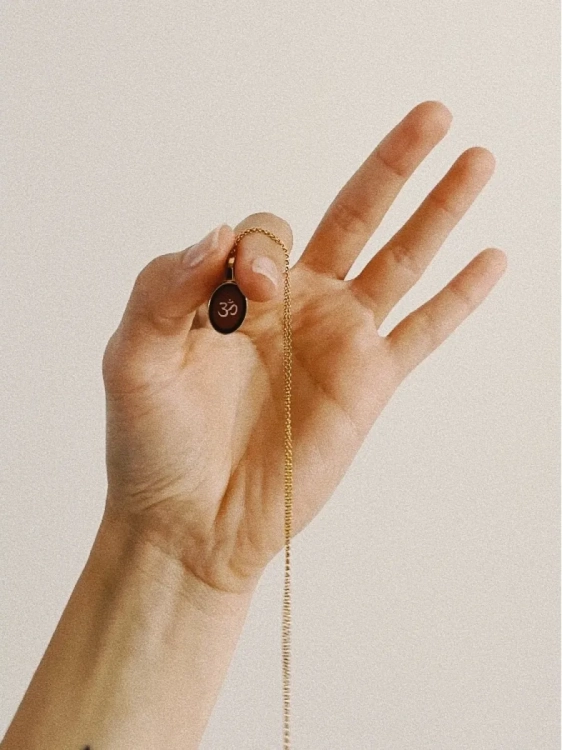 Gold-plated Om symbol necklace with amber worn during everyday styling