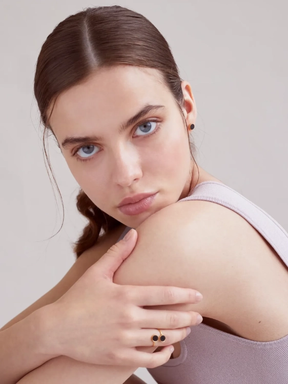 Gold-plated spiral ring with black chocolate flint worn on the hand