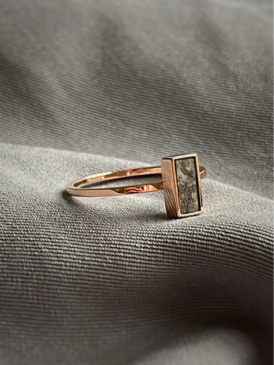 Minimal rose gold ring with natural meteorite, featuring a rectangular stone and a delicate band.