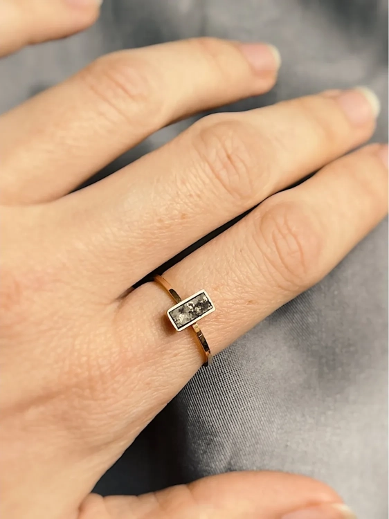 Handcrafted gold meteorite ring worn on the hand, showcasing the rectangular meteorite and slim rose gold band.