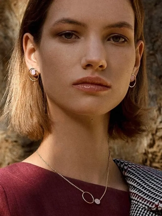 Elegant women’s gold earrings with natural pink stone